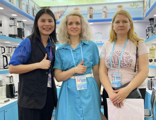 Foto grup tim Zhongshan Yuekon Electrical Appliances Co., Limited dengan klien internasional selama pertemuan bisnis, menampilkan kemitraan dan kolaborasi.