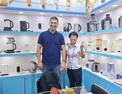 Gambar anggota tim Zhongshan Yuekon Electrical Appliances Co., Limited dan klien internasional tersenyum untuk foto grup, mencerminkan interaksi bisnis yang positif.