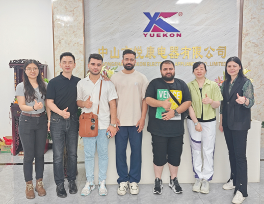 Zhongshan Yuekon Electrical Appliances Co., Karyawan terbatas dan klien internasional berpose bersama, melambangkan hubungan bisnis yang sukses dan kolaboratif.
